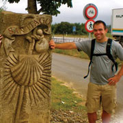 Student next to sign along el Camino in Spain.
