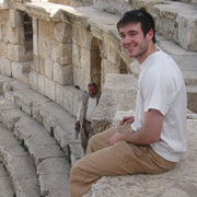 Student sitting at historic landmark in Jordan.